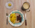 Mititei and fried potatoes with mustard and a mug of black beer Royalty Free Stock Photo