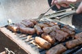 Mititei. Turn the mititei on the grill with a fork. Mititei or mici, typical romanian and moldavian food grilled ground meat rolls Royalty Free Stock Photo