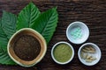 Mitragyna speciosa kratom leaves with medicine products in powder, capsules and tablet in white ceramic bowl on wood texture Royalty Free Stock Photo