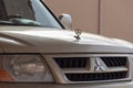 Mitsubishi logo on front of beige SUV Pajero model