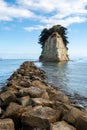 Mitsukejima diamond shaped island with trees on top of the rock, view with stone pier, on Noto Peninsula, Japan.