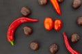 Mix of autumn vegetables chestnut brown circle chili peppers spicy tomato mini cherry on a dark background