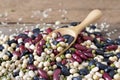 mix of beans on wooden spoon. green bean, soybean, black bean ,red bean and White kidney bean