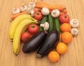 A mix of beneficial fruits and vegetables on wooden background - Bananas oranges eggplants tomatoes cucumbers carrots and Royalty Free Stock Photo
