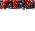 Mix berries and fruits at border of image with copy space for text. Ripe blueberries, blackberries and red currants on white back Royalty Free Stock Photo