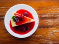 Mix berry cheese cake on white plate on wood background Royalty Free Stock Photo