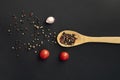 mix of black hot pepper, wooden bowl or spoon, black table or surfaces Royalty Free Stock Photo