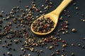 mix of black hot pepper, wooden bowl or spoon, black table or surfaces Royalty Free Stock Photo
