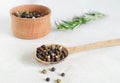 A mix of black, white, red and allspice peppercorns in a wooden spoon on a light background. dried spice peppercorn concept Royalty Free Stock Photo