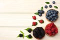 mix of blueberries, blackberries, raspberries in wooden bowl on light wooden table background Royalty Free Stock Photo