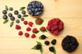 Mix of blueberries, blackberries, raspberries in wooden bowl on light wooden table background Royalty Free Stock Photo