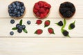 Mix of blueberries, blackberries, raspberries in wooden bowl on light wooden table background Royalty Free Stock Photo