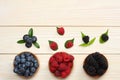 mix of blueberries, blackberries, raspberries in wooden bowl on light wooden table background. top view with copy space Royalty Free Stock Photo