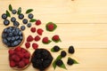 mix of blueberries, blackberries, raspberries in wooden bowl on light wooden table background. top view with copy space Royalty Free Stock Photo