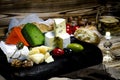 Mix cheese on dark background on wood board with grapes, honey, nuts, tomatoes and basil. Top view Royalty Free Stock Photo