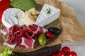 Mix cheese and meat on white background on wood board with grapes, honey, nuts, tomatoes and basil. Top view Royalty Free Stock Photo
