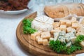 Mix cheese on wooden board with meat and bread Royalty Free Stock Photo