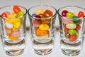 A mix of colored jelly beans candy in shot glasses.