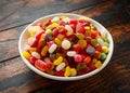 A mix of colorful candy in white bowl on wooden table Royalty Free Stock Photo