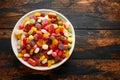 A mix of colorful candy in white bowl on wooden table Royalty Free Stock Photo