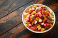 A mix of colorful candy in white bowl on wooden table Royalty Free Stock Photo