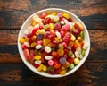 A mix of colorful candy in white bowl on wooden table Royalty Free Stock Photo