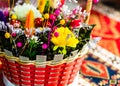Mix of colorful spring flowers in a braided wicker basket