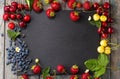 Mix of delicious juicy spring berries on a black stone board Royalty Free Stock Photo