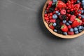 Mix of different fresh berries in bowl on table, top view. Space for text Royalty Free Stock Photo