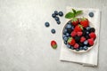 Mix of different fresh berries in bowl on light grey table, flat lay. Space for text Royalty Free Stock Photo