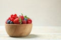 Mix of different fresh berries in bowl on table. Space for text Royalty Free Stock Photo