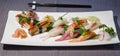 Mix of different nigiri on a bamboo leaf served with daikon and Royalty Free Stock Photo