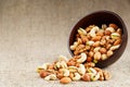 Walnut platter spilled out of the cup on the background of cloth from burlap. Nuts as structure and background, macro Royalty Free Stock Photo