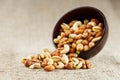 Walnut platter spilled out of the cup on the background of cloth from burlap. Nuts as structure and background, macro Royalty Free Stock Photo