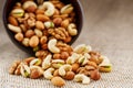 Walnut platter spilled out of the cup on the background of cloth from burlap. Nuts as structure and background, macro Royalty Free Stock Photo