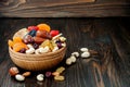 Mix of dried fruits and nuts on a dark wood background with copy space. Symbols of judaic holiday Tu Bishvat. Royalty Free Stock Photo