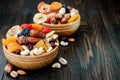 Mix of dried fruits and nuts on a dark wood background with copy space. Symbols of judaic holiday Tu Bishvat.