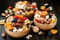 Mix of dried fruits and nuts on a dark wood background with copy space. Symbols of judaic holiday Tu Bishvat.