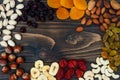 Mix of dried fruits and nuts on a dark wood background with copy space. Top view. Symbols of judaic holiday Tu Bishvat. Royalty Free Stock Photo