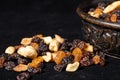 Mix of energetic seeds and dried fruits in a wooden bowl on a black surface. Close up Royalty Free Stock Photo