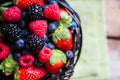 Mix of fresh berries in a basket on rustic wooden background Royalty Free Stock Photo