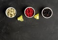 Mix of fresh berries in in bowls on black table . Antioxidants, detox diet, organic fruits. Flat lay with copy space. Royalty Free Stock Photo