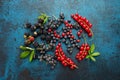 Mix of fresh berries with leaves on textured metal background Royalty Free Stock Photo