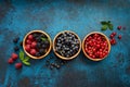 Mix of fresh berries with leaves on textured metal background Royalty Free Stock Photo