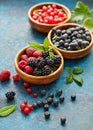 Mix of fresh berries with leaves on textured metal background Royalty Free Stock Photo