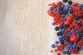 Mix of fresh berries on wooden background