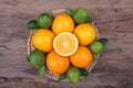 Mix of fresh citrus fruits in basket on wood Royalty Free Stock Photo