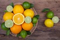 Mix of fresh citrus fruits in basket on wood Royalty Free Stock Photo