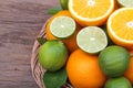 Mix of fresh citrus fruits in basket on wood Royalty Free Stock Photo