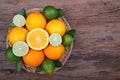 Mix of fresh citrus fruits in basket on wood Royalty Free Stock Photo